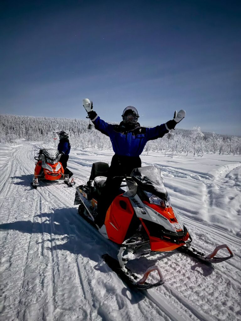 Moottorikelkkasafarin vetäjä lumisessa maastossa
